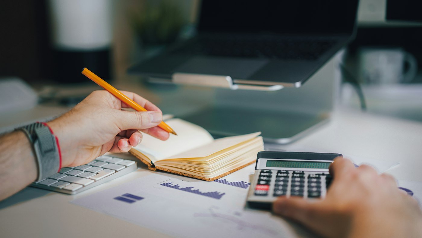 Calculator and financial statements illustrating GST sales reconciliation
